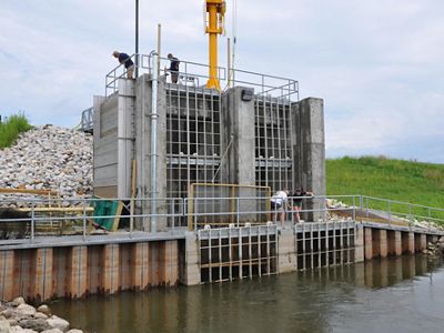 The water control structure at Emiquon during construction with four people standing on it.