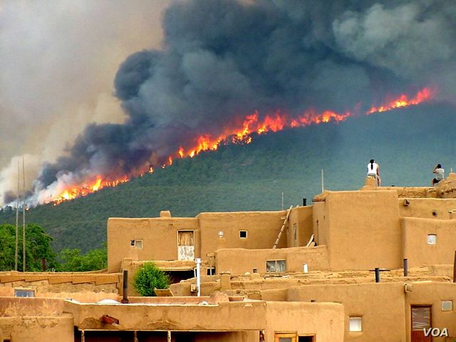 People watch the wildfire from their rooftops at the Taos Pueblo in New Mexico.