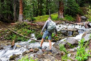 A person climbs over rocks during a hike.