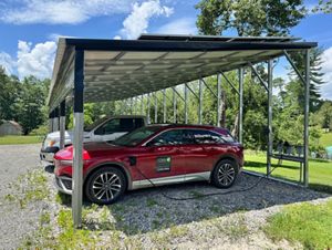 Electric cars parked under a solar powered carport used for charging.
