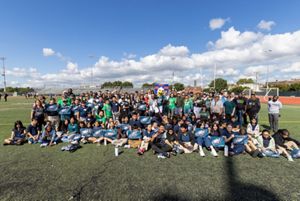 A wide group shot of event attendees posing together the field of the South Philadelphia Super Site.