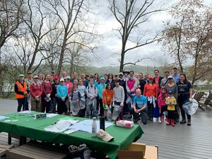 A large group of volunteers pose before beginning an Earth Day cleanup.