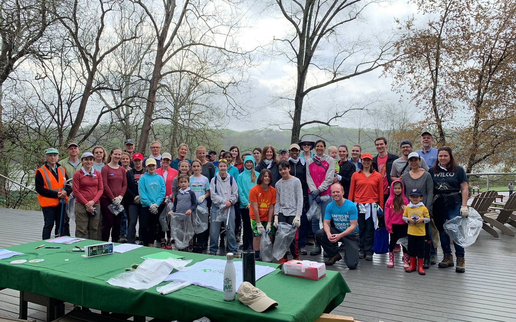 A large group of volunteers pose before beginning an Earth Day cleanup.
