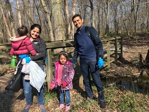 Parents with their two small children pose during an Earth Day cleanup.