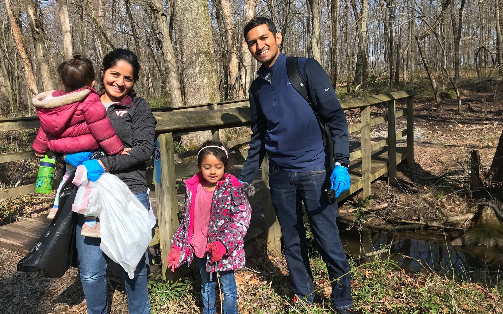 Parents with their two small children pose during an Earth Day cleanup.