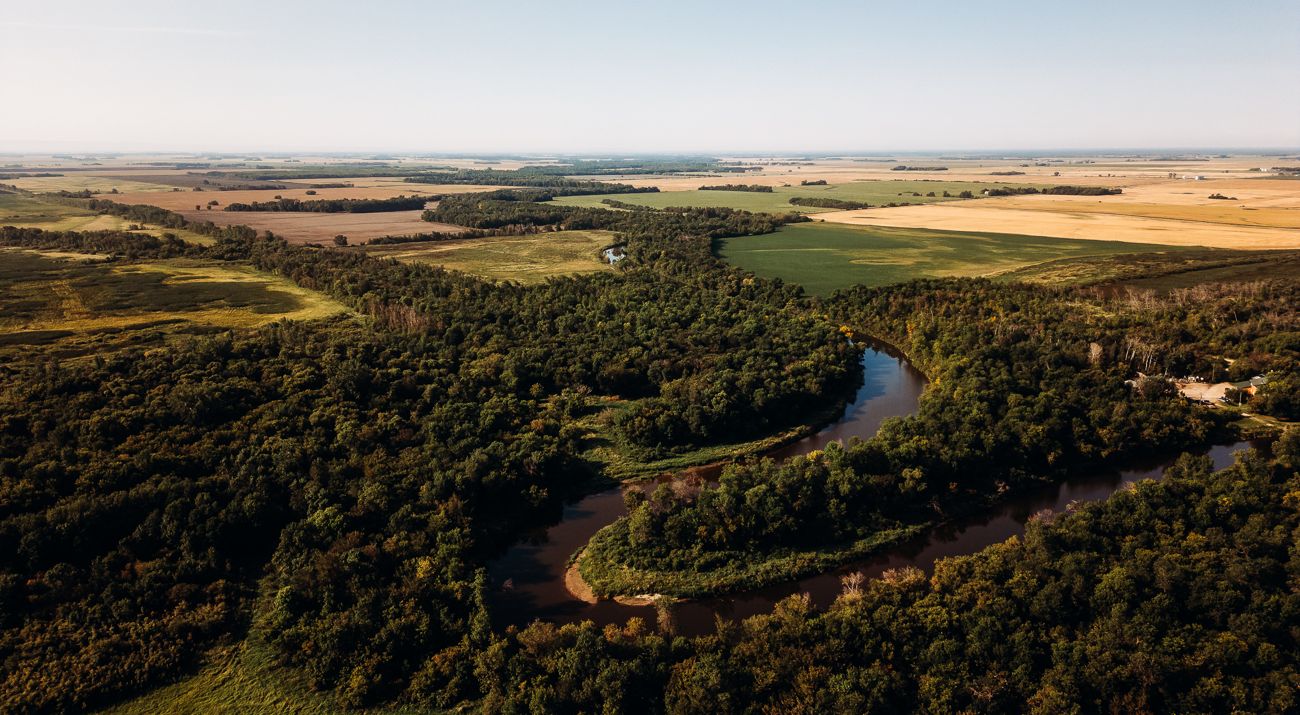 A river winding through forest and farmlands.