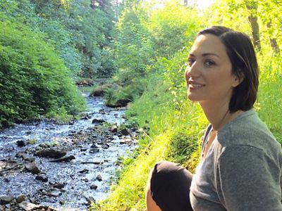 Fawn Bergen sitting next to a small river.