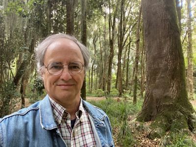 Felipe Edwards stands in a lush forest