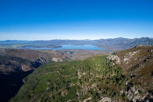 An aerial view features South Africa's mountains and forests.