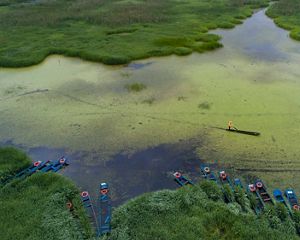 A fisher pushes his canoe through a river in Yunnan.