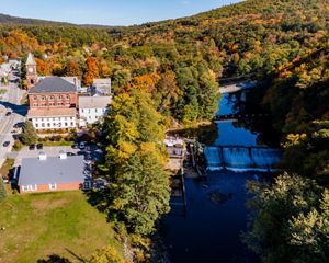 An overhead view of a dam on a river in the fall.