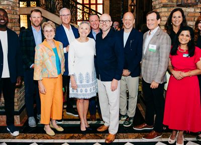 A group of people making up the Florida Board of Trustees pose together and smile at a Philanthropy dinner in Miami, Florida.