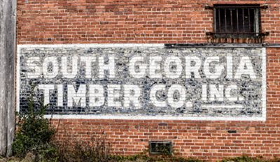 A black and white sign is painted on a red brick building.