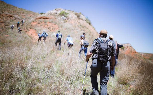 A group of hikers climb up a hill in the Oklahoma Canyons.