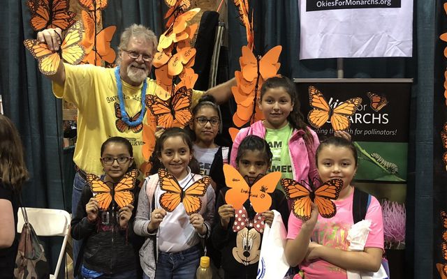Group of young girls holding their decorated monarch butterflies. 
