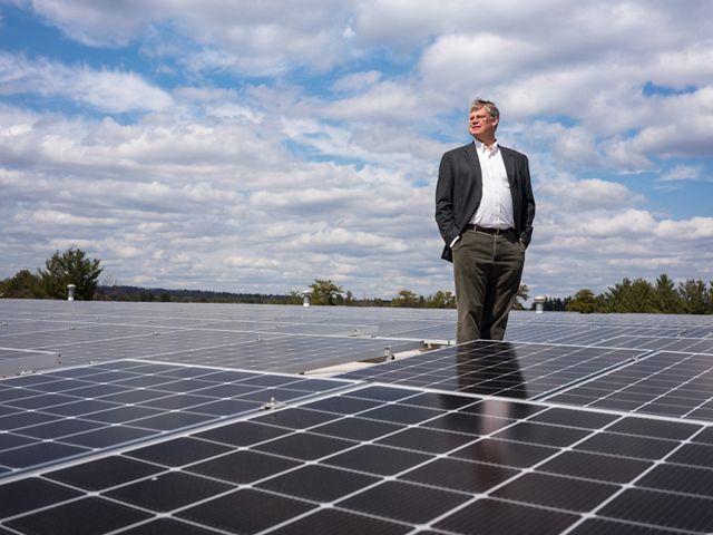 David Worthen, owner of Worthen Industries in Nashua, N.H., stands between more than 2700 solar panels installed on the roof of his adhesive manufacturing plant. Last summer, David invited New Hampshire’s governor to tour Worthen Industries and hosted a roundtable discussion about investing more money in renewables in the state.