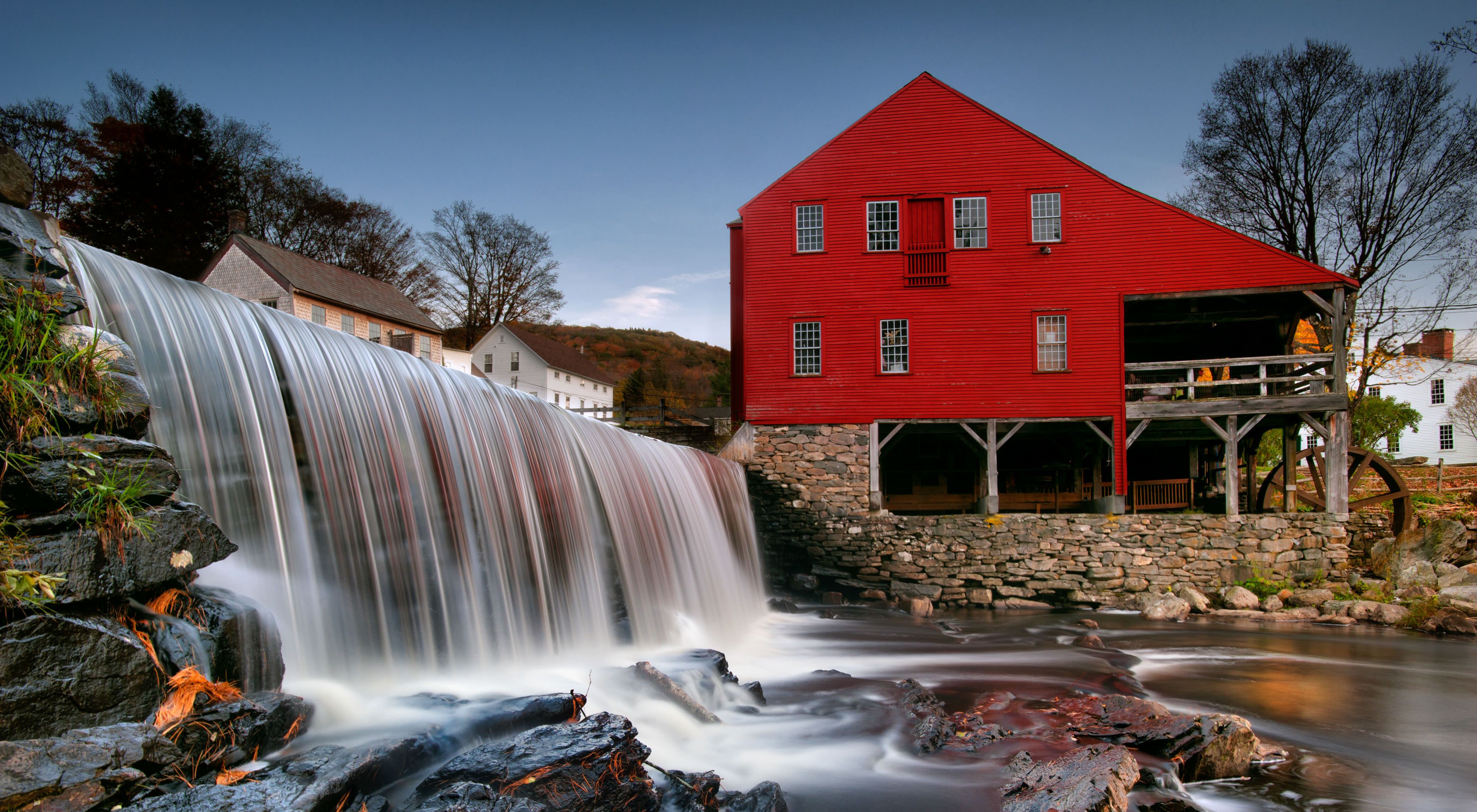 A small waterfall near an old red mill.