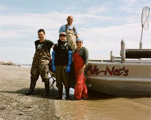4 people in waders stand beside boat pulled onto rocky