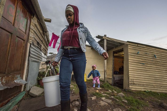 Perched on a hill overlooking the vast Atlantic Ocean, Redhill is an informal settlement of about 1000 residents living in small makeshift homes. Thobeka (17 years old), her mama and 1-year-old sister live here in a one bedroom home with no running water. The family fetches water from a communal water tap for daily use (cooking, brushing teeth etc). Due to the severe water crisis at the time, this community tap would be waterless a few times a week. During those times, Thobeka would have to walk down to the bottom of the hill to bring water in a bucket (about a 1- hour process). As a family they would use 1 bucket of water 
(approximately 20 liters) per day for cooking and drinking. 
Above: Thobeka going to fetch water (her sister in the background).