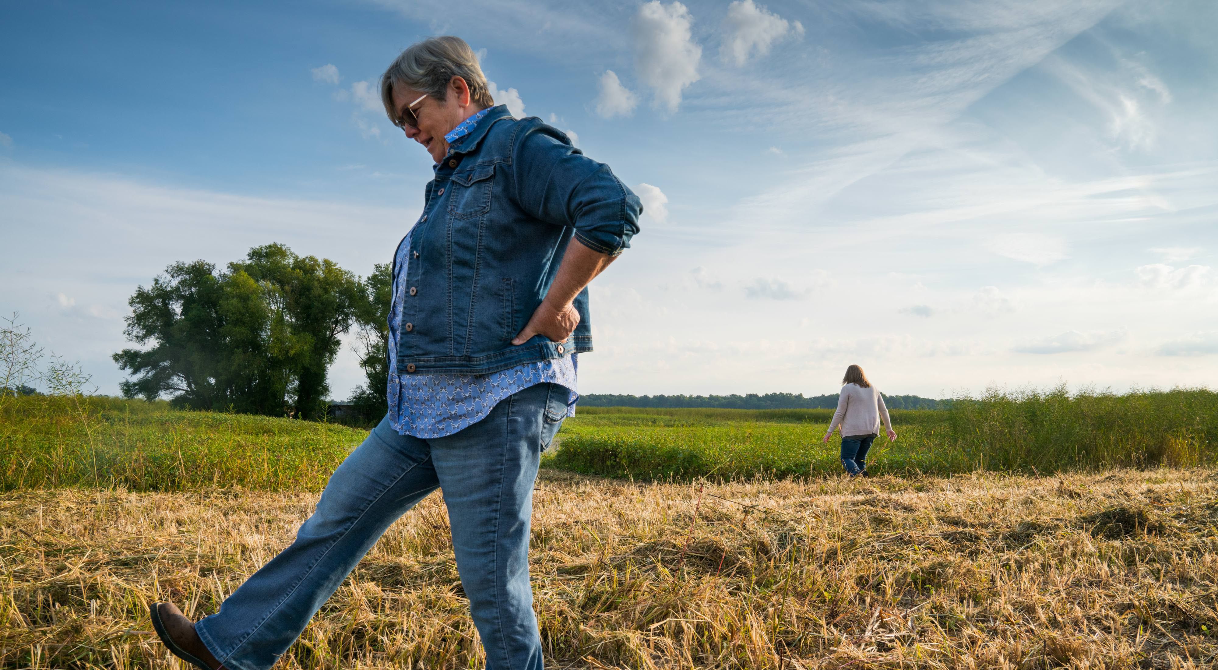 A woman kicks at the grass on her family's farm