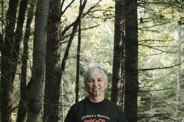 Margo Robbins, a Yurok Tribe member, stands in the forest.