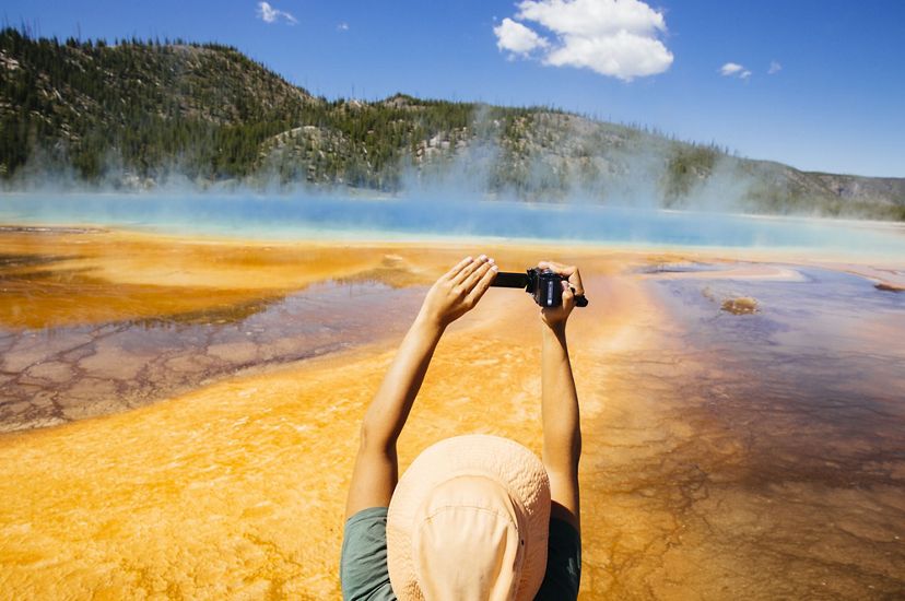 A tourist takes a photo of the Grand Prismatic Spring in Yellowstone National Park.