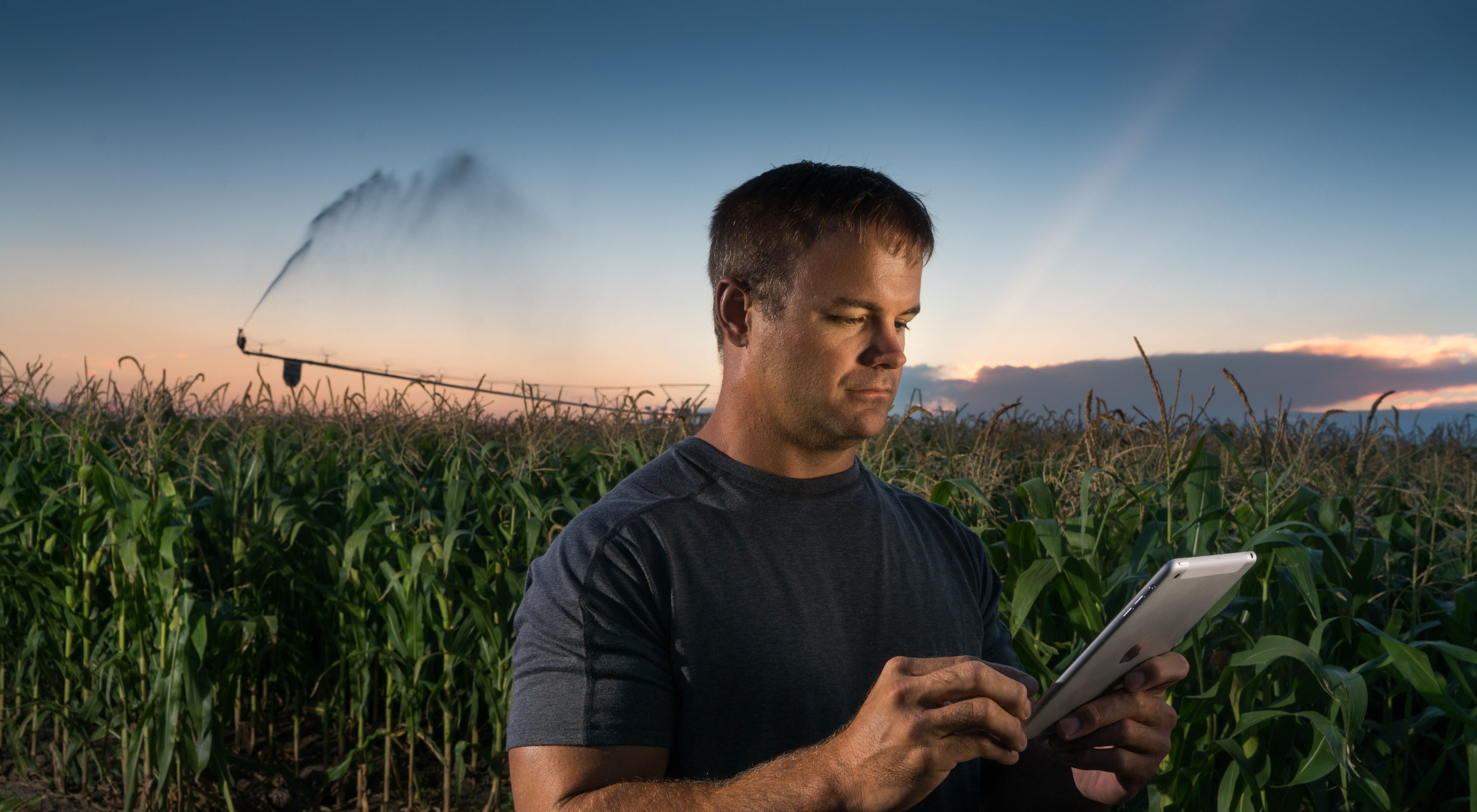Nebraska Farmer Mike Svoboda stands in his field using a tablet to control the irrigation