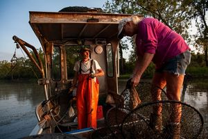 Two people work on a fishing boat.