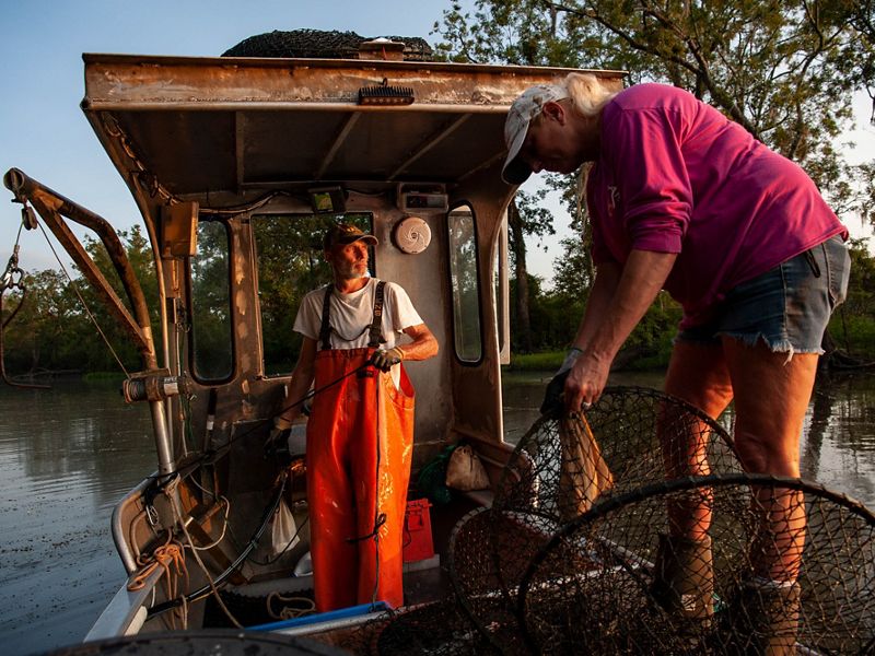 Two people work on a fishing boat.
