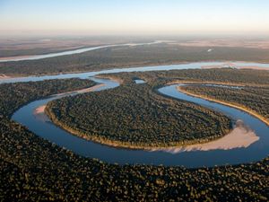 River with big bend surrounded by forests at sunrise. 