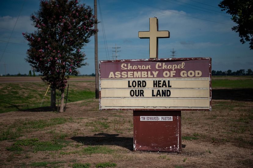 A sign for Church of Christ Assembly of God says, "Lord Heal Our Land."