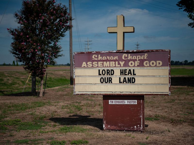A sign for Church of Christ Assembly of God says, "Lord Heal Our Land."