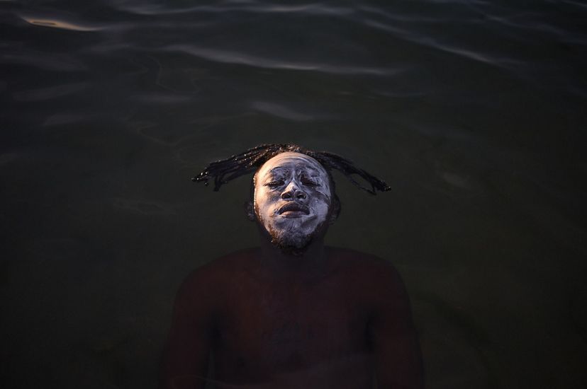 a man's face breaks the surface of a river