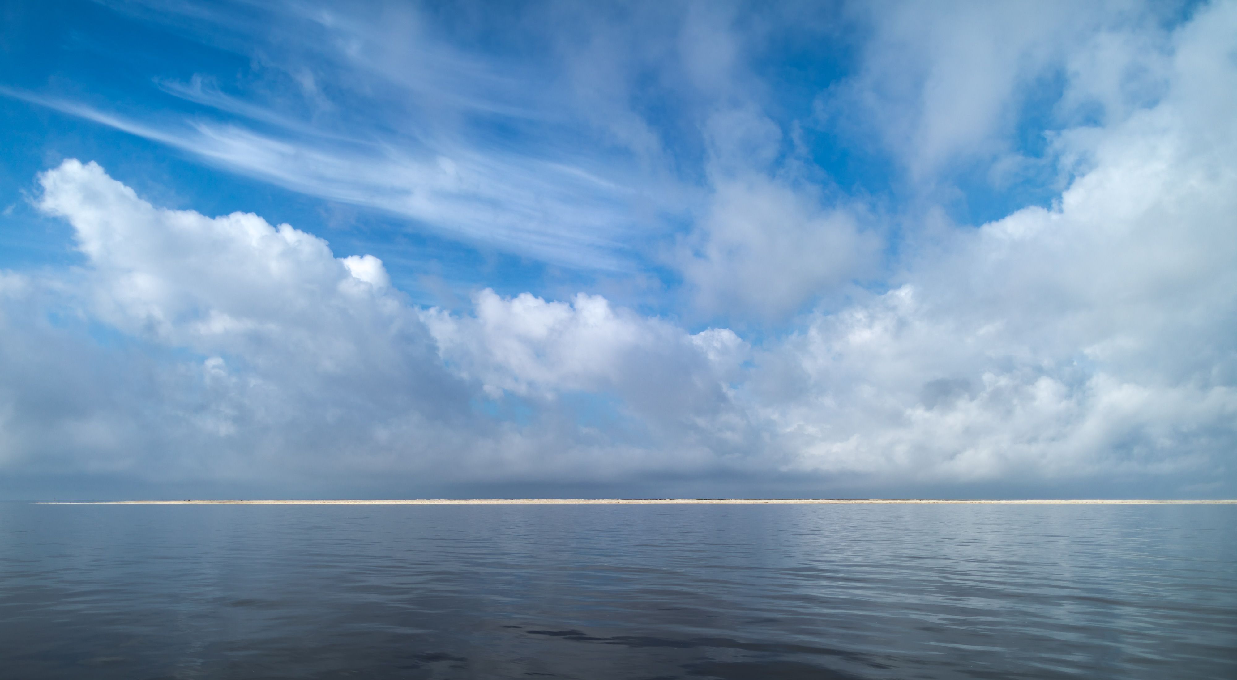 New Round Island near Pascagoula, Mississippi, looks like a sandbar between blue ocean and blue sky