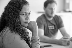 A seated woman listens intently to a Techstars presenter. 