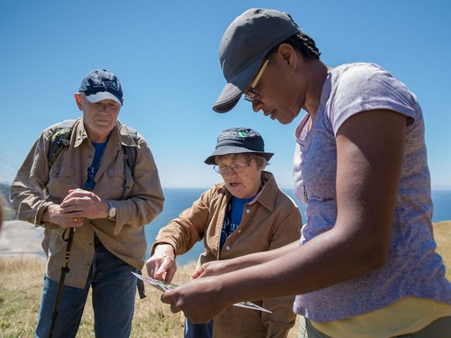 Two volunteers help a hiker at Cascade Head Preserve