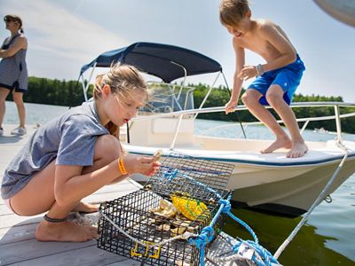 Two kids inspect an oyster cage