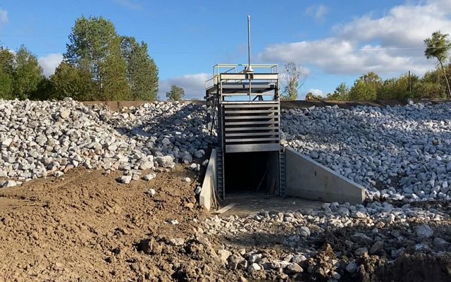 Water control structure surrounded by rocks and dirt in Loch Leven.