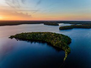 Aerial view of a pond with some islands and shoreline at sunrise