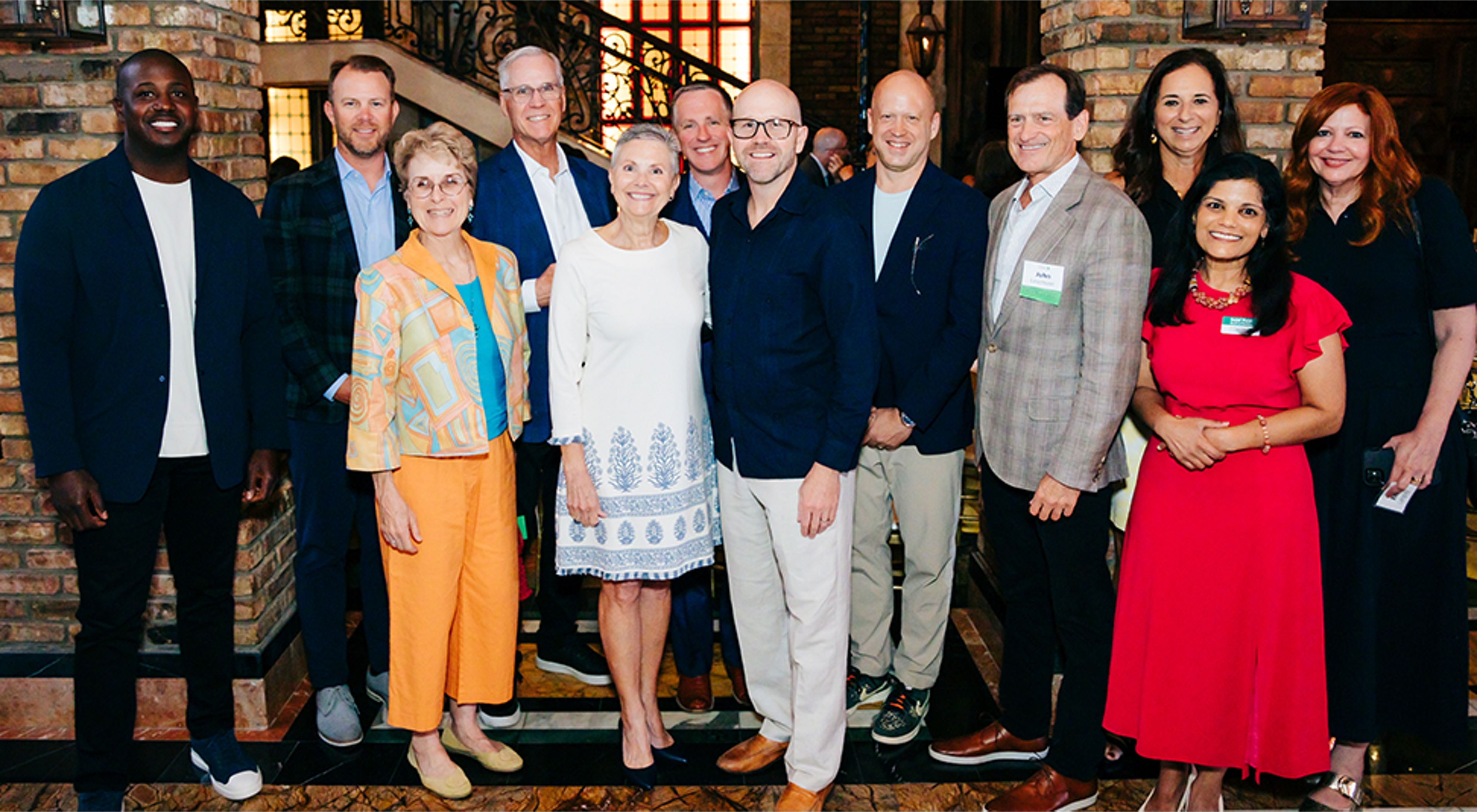 A group of people making up the Florida Board of Trustees pose together and smile at a Philanthropy dinner in Miami, Florida.