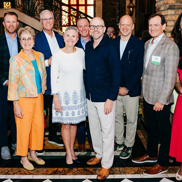 A group of people making up the Florida Board of Trustees pose together and smile at a Philanthropy dinner in Miami, Florida.