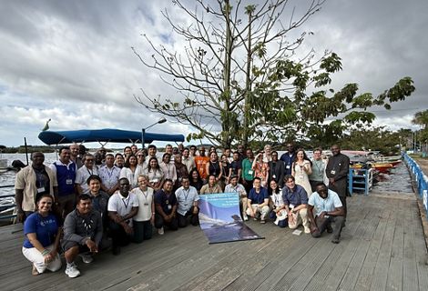 Group of workshop participants gather in front of a river.