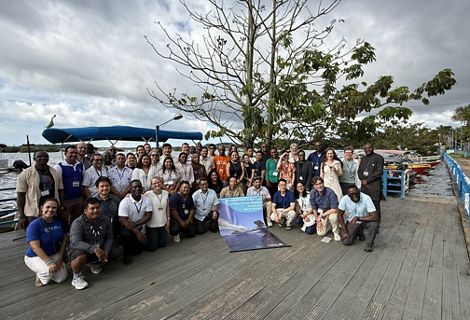 Grupo de participantes do workshop reunidos em frente a um rio.