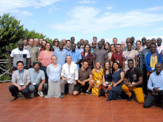 A group of people smiling while gathered for a group photo.