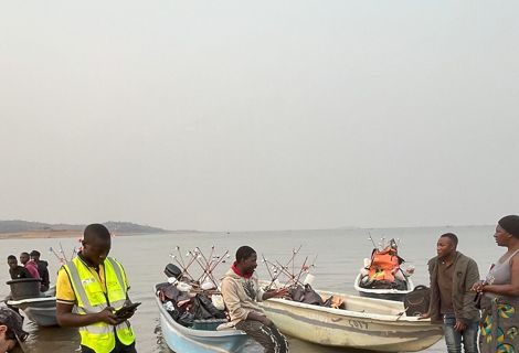 People standing or sitting on or near fishing boats.