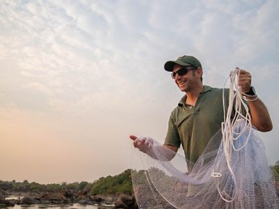 Photo of Bruce Ellender smiling and holding a fishing net.