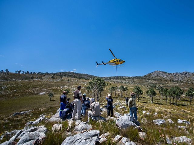 People looking at a yellow helicopter