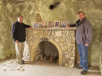 Geoffrey Standing Bear, Osage Nation Chief, stands in front of a fireplace with conservationist and wildlife photographer Harvey Payne.