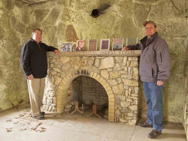 Geoffrey Standing Bear, Osage Nation Chief, stands with Harvey Payne next to the fireplace in John Joseph Mathews Cabin. 