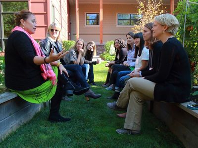 Several people sit across from each other on outdoor benches and have a discussion at the Women in Climate conference.
